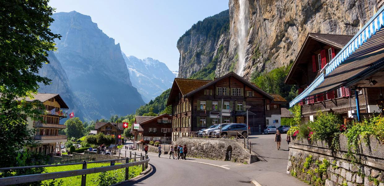 Uliczka w Alpach Szwajcarskich z charakterystycznymi budynkami, idealnym miejscem dla motocyklistów szukających pięknych tras.