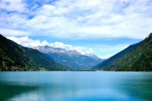 Spokojne wody Lago di Poschiavo otoczone szwajcarskimi Alpami