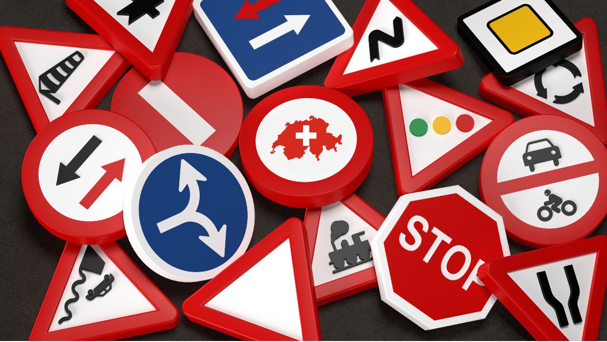 Zbiór różnorodnych szwajcarskich znaków drogowych, w tym znaki zakazu, nakazu, informacyjne i ostrzegawcze, ułożonych na czarnym tle, symbolizujących przepisy ruchu drogowego w Szwajcarii.